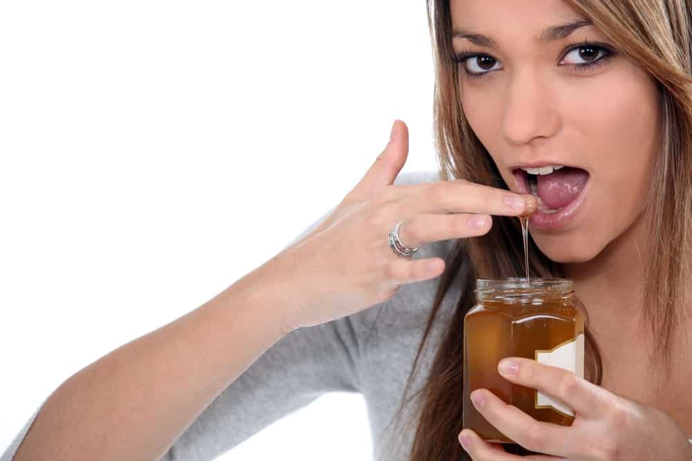 Woman Eating Honey With Finger